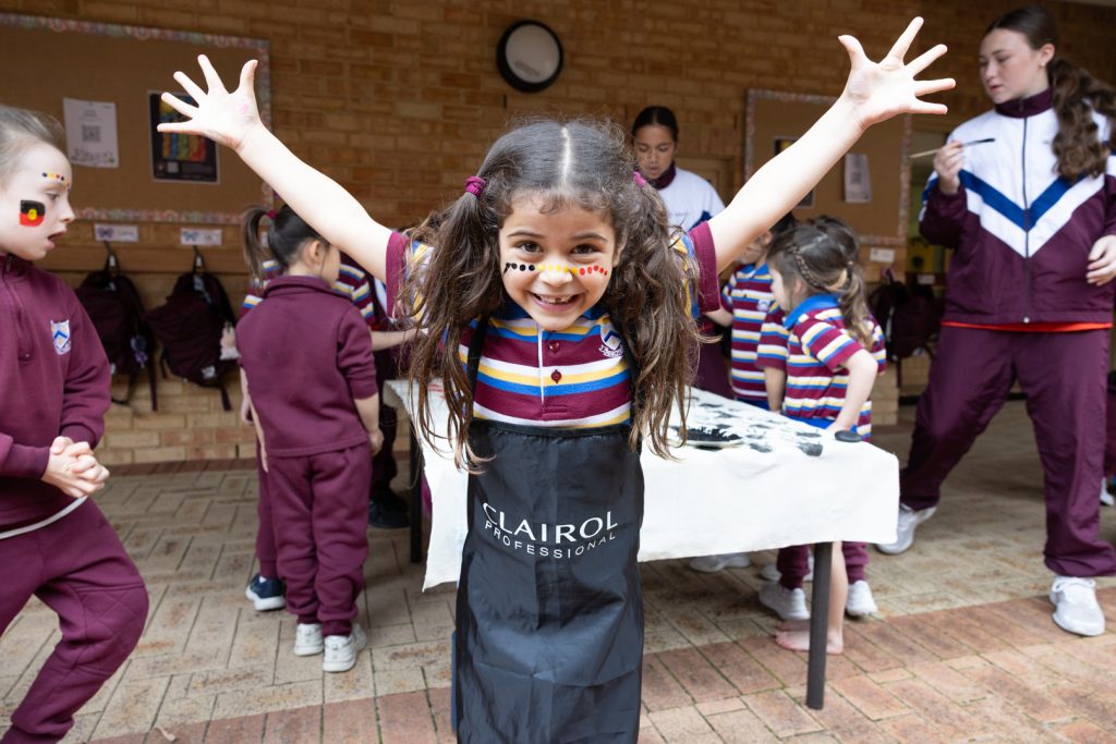 A Junior School student proudly showing off her face painting