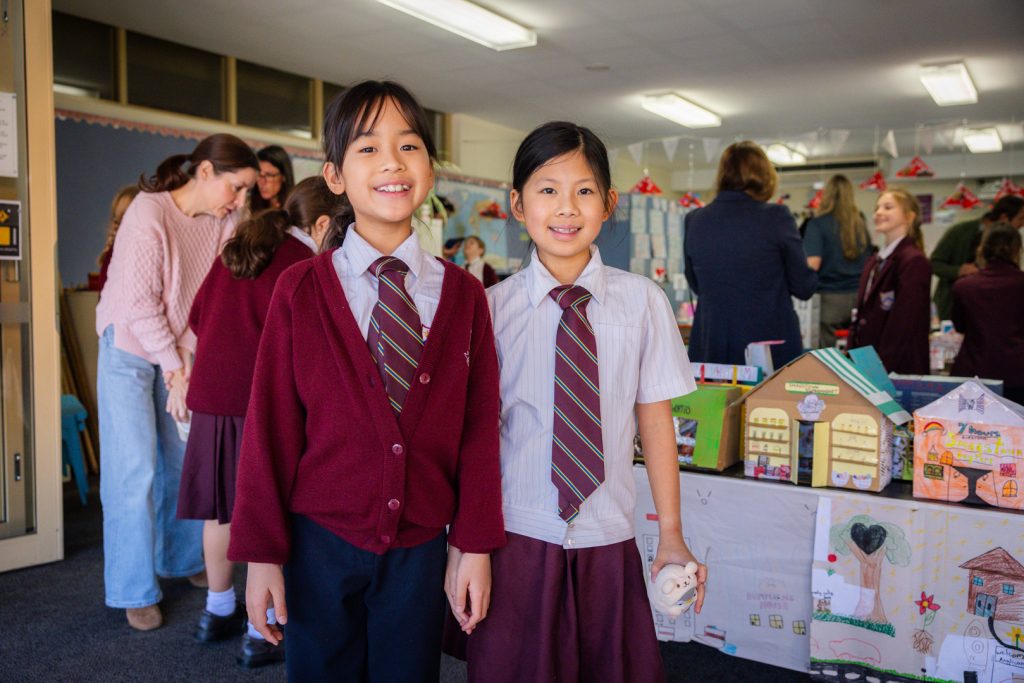 Students smiling proudly in front of Smagstown model