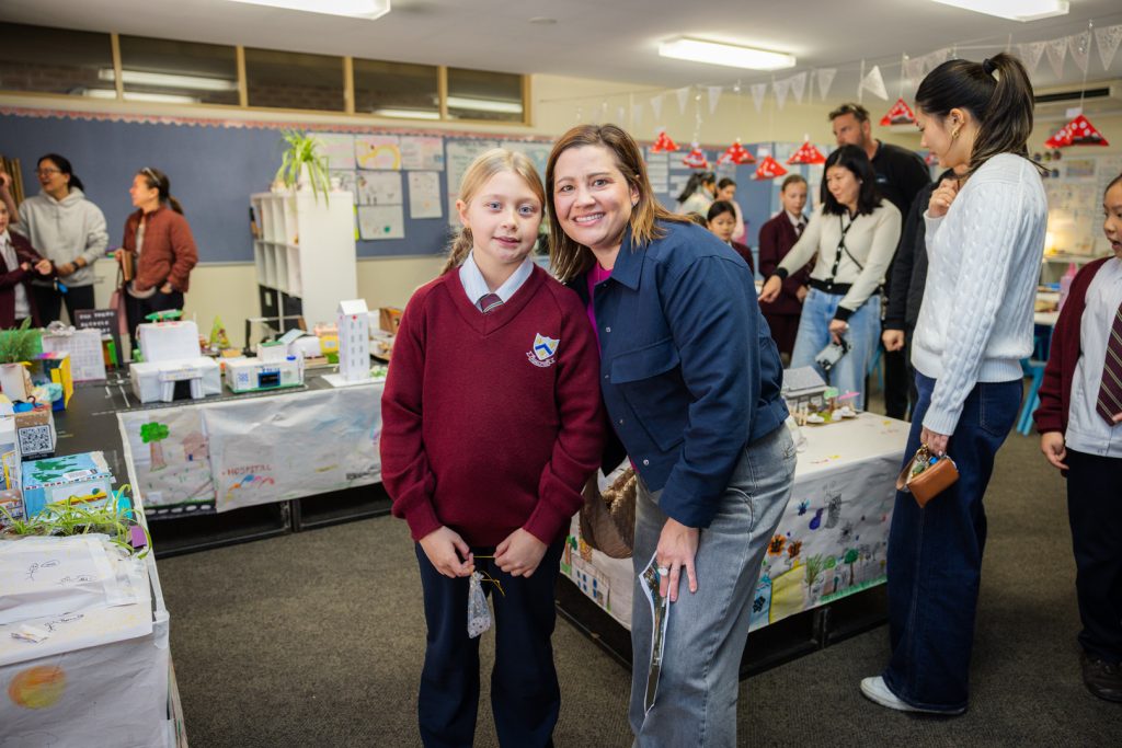 A student with her parent or guardian smiling proudly in front of Smagstown